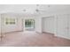 A bright bedroom boasts a ceiling fan and sliding doors that offer a view of the inviting swimming pool at 18112 Windswept Av, Port Charlotte, FL 33948