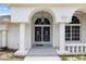 Home featuring an arched entry way, white columns, and an eye-catching door at 18112 Windswept Av, Port Charlotte, FL 33948