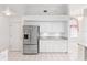 Bright kitchen with stainless steel refrigerator, white cabinets, and granite countertops at 18112 Windswept Av, Port Charlotte, FL 33948