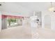 Bright living room featuring tile flooring, a ceiling fan, and views into the kitchen and outdoor pool area at 18112 Windswept Av, Port Charlotte, FL 33948