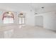 Spacious living room with carpet flooring, ceiling fan, and arched windows at 18112 Windswept Av, Port Charlotte, FL 33948