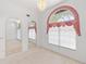 Bright living room featuring carpet flooring, arched window, and chandelier at 18112 Windswept Av, Port Charlotte, FL 33948