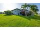 Exterior shot of the property showing the lush lawn and the screened in pool at 204 W Pine Valley Ln, Rotonda West, FL 33947