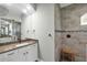 Bathroom featuring a granite vanity, walk-in shower with rain head, and elegant tile work at 204 W Pine Valley Ln, Rotonda West, FL 33947