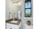 Bathroom features a vanity with granite counters, modern lighting, and a framed mirror at 204 W Pine Valley Ln, Rotonda West, FL 33947