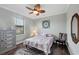 Cozy bedroom features wood flooring, a ceiling fan, and a window for natural light at 204 W Pine Valley Ln, Rotonda West, FL 33947