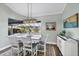 Sunlit dining area with modern lighting fixture and serene views of the screened outdoor living space at 204 W Pine Valley Ln, Rotonda West, FL 33947