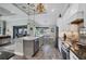 Bright, open kitchen with an island, stainless steel appliances and adjacent dining area overlooking the lanai at 204 W Pine Valley Ln, Rotonda West, FL 33947