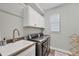 This laundry room features modern appliances, built-in cabinets, and a granite sink at 204 W Pine Valley Ln, Rotonda West, FL 33947
