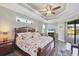 Spacious main bedroom with tray ceiling, wood-look tile floors, and sliding glass doors to lanai at 204 W Pine Valley Ln, Rotonda West, FL 33947