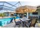 Relaxing poolside patio with comfortable seating, an umbrella, and a view of the golf course at 204 W Pine Valley Ln, Rotonda West, FL 33947