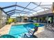 Enclosed pool area with brick patio, outdoor seating, and view of the house at 204 W Pine Valley Ln, Rotonda West, FL 33947