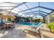 Outdoor dining and lounge area with seating surrounding the screened in pool at 204 W Pine Valley Ln, Rotonda West, FL 33947