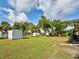 Large backyard with a metal storage shed, mature trees, and a fenced perimeter at 21519 Fairway Ave, Port Charlotte, FL 33952