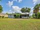 Exterior shot of the home featuring an enclosed back porch and partial view of the green grass at 21519 Fairway Ave, Port Charlotte, FL 33952