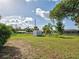 Spacious fenced backyard with a storage shed and mature trees, perfect for outdoor activities at 21519 Fairway Ave, Port Charlotte, FL 33952