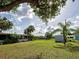 Backyard with mature trees and a partial view of a screened in porch at 21519 Fairway Ave, Port Charlotte, FL 33952