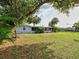Backyard featuring mature trees with a partial view of a screened in porch at 21519 Fairway Ave, Port Charlotte, FL 33952