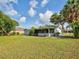 Wide shot of the backyard featuring a screened in porch and large green grass area at 21519 Fairway Ave, Port Charlotte, FL 33952