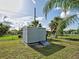 A metal backyard shed sits on a grassy lot with a ramp for easy access to store lawn and garden supplies at 21519 Fairway Ave, Port Charlotte, FL 33952