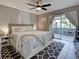 Bedroom features a ceiling fan and access to screened patio at 21519 Fairway Ave, Port Charlotte, FL 33952