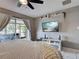 Bedroom features a ceiling fan, tv and access to screened patio at 21519 Fairway Ave, Port Charlotte, FL 33952