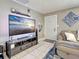 Cozy living area features tile flooring, a plush couch, and a large screen TV for entertainment at 21519 Fairway Ave, Port Charlotte, FL 33952
