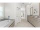 Bright bathroom with soaking tub, double vanity, tile floor, and neutral color scheme at 22 Par View Rd, Rotonda West, FL 33947