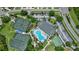 Aerial view of resort-style community clubhouse with a pool, tennis courts, playground, and parking at 2592 Brassica Dr, North Port, FL 34289