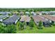 A lush backyard with green lawns and tropical trees, plus a screened in porch for relaxing at 2592 Brassica Dr, North Port, FL 34289