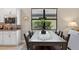 Dining area featuring a dark wooden table with seating for six and views of the landscaped backyard at 2592 Brassica Dr, North Port, FL 34289