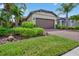 Charming single-story home with a brick driveway, lush landscaping and a two-car garage at 2592 Brassica Dr, North Port, FL 34289