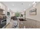 Modern kitchen with granite counters, stainless appliances, and open to the dining and living area at 2592 Brassica Dr, North Port, FL 34289