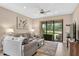 Living room with sliding glass doors leading to outdoor seating and a ceiling fan at 2592 Brassica Dr, North Port, FL 34289