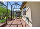 Covered screened patio with brick flooring, offering an outdoor cooking and dining space at 2592 Brassica Dr, North Port, FL 34289