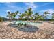 Beautiful community pool featuring blue tiled water, tropical vegetation, and lounge chairs under shady canopies at 2592 Brassica Dr, North Port, FL 34289