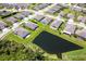 Scenic aerial view of homes nestled in a community near a tranquil pond and greenery at 267 Talquin Ct, Englewood, FL 34223