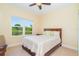 Comfortable bedroom with a ceiling fan and a picturesque view of the pond at 267 Talquin Ct, Englewood, FL 34223