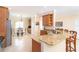 Open kitchen featuring a granite counter bar, tile floors, and wooden cabinets at 267 Talquin Ct, Englewood, FL 34223