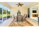 The screened lanai features a ceiling fan, a glass table with chairs, and views of the backyard at 267 Talquin Ct, Englewood, FL 34223