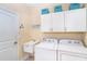 Laundry room with white cabinets, a utility sink, and modern appliances at 267 Talquin Ct, Englewood, FL 34223