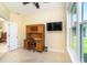 A home office with desk, chair, television, and sun-filled window at 267 Talquin Ct, Englewood, FL 34223