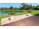 Brick paver patio featuring beautiful potted plants with scenic pond views beyond at 267 Talquin Ct, Englewood, FL 34223