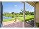 View from the patio with brick pavers overlooking a tranquil pond and lush green landscape at 267 Talquin Ct, Englewood, FL 34223