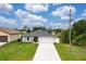 Aerial view of a single-story home with a driveway, green lawn, and well-maintained landscaping at 271 Antis Dr, Rotonda West, FL 33947