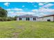 Home exterior showcasing a well-maintained backyard with a spacious lawn and sliding glass doors at 271 Antis Dr, Rotonda West, FL 33947
