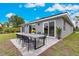 Home exterior showing outdoor dining on a paved patio, complete with sleek outdoor furniture and lush greenery at 271 Antis Dr, Rotonda West, FL 33947