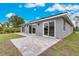 Home exterior boasting sliding glass doors that open to a stone-paved patio and green lawn at 271 Antis Dr, Rotonda West, FL 33947