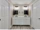 Stylish bathroom featuring a double sink vanity, open medicine cabinets, and modern lighting fixtures at 271 Antis Dr, Rotonda West, FL 33947