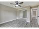Bright bedroom with grey, wood-look flooring, ceiling fan, and mirrored closet doors at 271 Antis Dr, Rotonda West, FL 33947